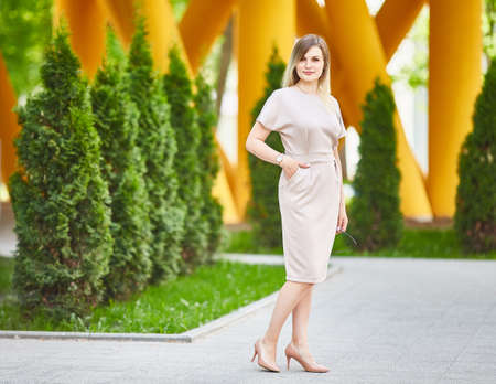 woman walking down the street. A lady in a stylish summer dress. The concept of womens fashion. Urban lifestyle. Sunny day.の写真素材