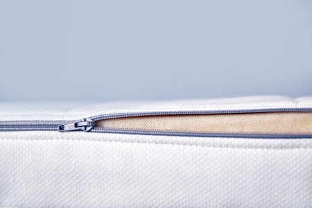 Orthopedic mattress with removable cover. Hand unzips the zipper close-up. Copy spaceの写真素材
