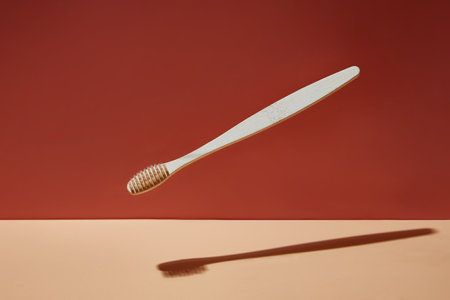 Wooden biodegradable bamboo toothbrush drops on a colored background. Health, environment and zero waste concept.の写真素材