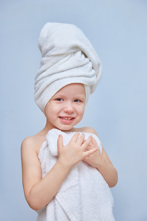 little girl or daughter in towels relaxes and rests in a spa salon on a plain background.の写真素材