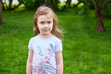 A five-year-old girl on a summer day on the street.