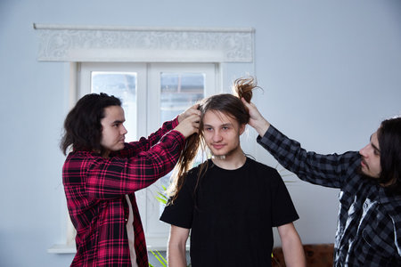 friendship and entertainment concept - three guys having fun and fooling around at home.の写真素材