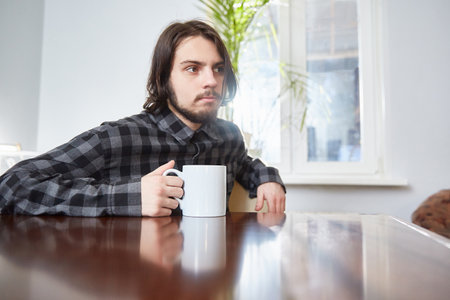 A cup in the hands of a young man. Focus on the cupの写真素材