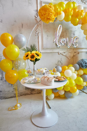 Delicious sweet holiday buffet with cupcakes, meringues and other desserts. Background of balloons. Vertical frameの写真素材