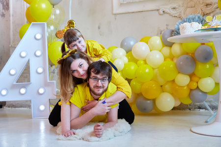 young family with a girl having fun at the celebration of their daughters fourth birthday.の写真素材