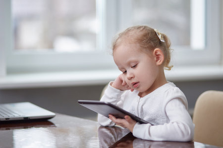 Child with a tablet at the table. Copy spaceの写真素材