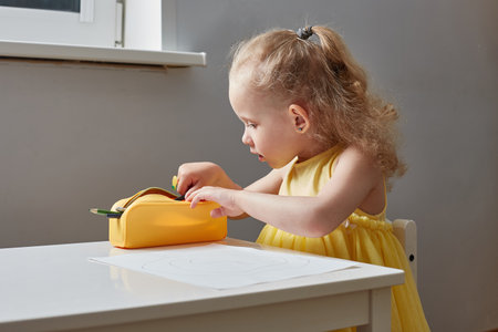 The girl picking up pencils in a pencil caseの写真素材