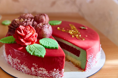 A close-up cut of a berry vanilla mousse cake with edible flowers