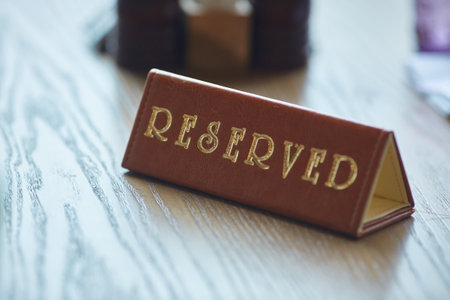 Restaurant reserved table sign. A brown reserved sign is on the table.