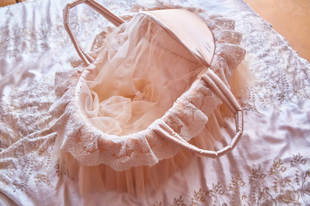 Beautiful carrycot or cradle with lace and ribbons for a newborn baby.の写真素材