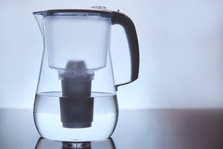 Transparent Water Filter Pitcher on Reflective Surfaceの写真素材