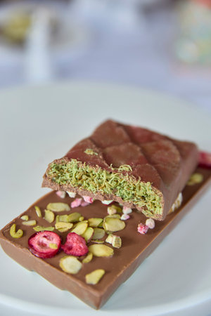 Dubai chocolate. Richly layered chocolate embraces a vibrant pistachio cream, hinting at indulgence and sweet contentment, perfect for marketing decadent confections or celebrating moments of pleasure.の写真素材