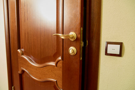 Partially Open Wooden Door with Gold Handle