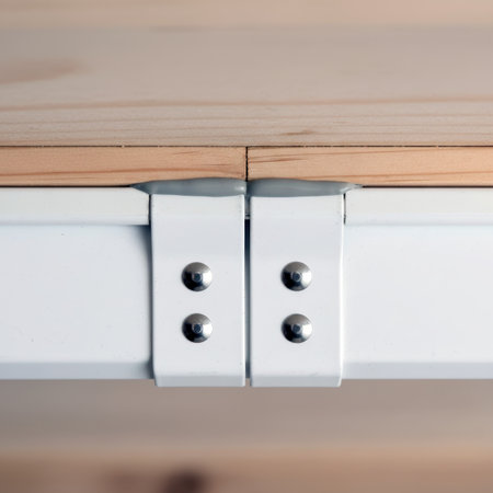 Close up of a white metal bracket with rivets joining wooden shelf panels.の素材