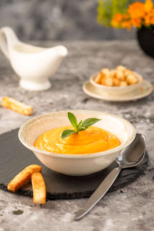 Creamy carrot and pumpkin puree, on a gray stone background. Selective focus.の写真素材