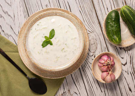 Greek tzatziki sauce on a gray background. Traditional Indian raita with cucumber, greek yogurt and coriander, top viewの写真素材