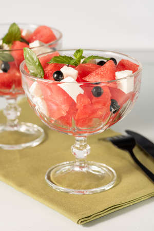 Summer organic salad with watermelon, feta cheese, black currant and mint. Light dietary breakfast. Selective focus.の写真素材