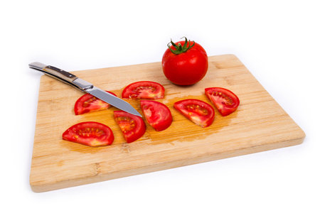Tomato on cutting board with knifeの写真素材
