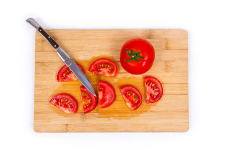 Tomato on cutting board with knifeの写真素材