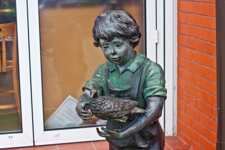 RUSSIA, ZELENOGRADSK - OCTOBER 11, 2014: Sculpture of a boy with bird in the Zelenogradsk promenade. Zelenogradsk (Cranz) is a resort town in Kaliningrad Oblast, Russia, near the Curonian Spit on the Baltic Sea.のeditorial素材