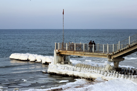 Tourists on a long jetty looking the Baltic Sea in the popular russian resort of Svetlogorsk (Rauschen) on a sunny winter day.の写真素材