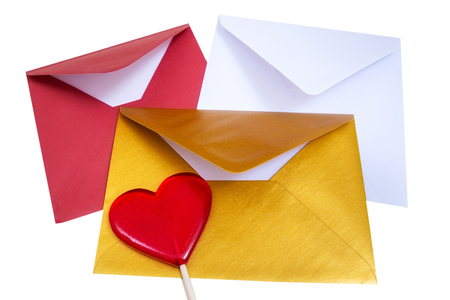 Group of open multicolored envelopes with red lollipop in the shape of a heart on the white background.の写真素材