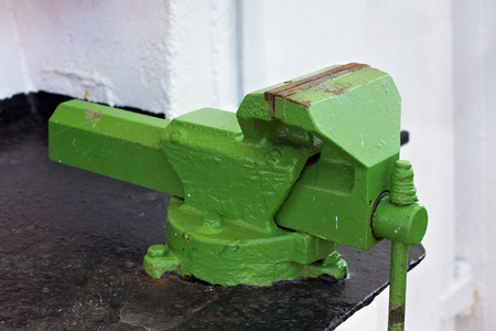 Large old green vise on the steel black table.の写真素材