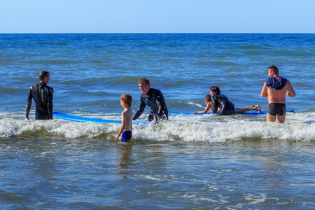 ZELENOGRADSK, KALININGRAD REGION, RUSSIA - JULY 29, 2017: Unknown children resting and learning of surfing with professional instructors on the blue waves of the Baltic Sea at summer time.のeditorial素材