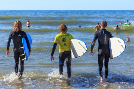 ZELENOGRADSK, KALININGRAD REGION, RUSSIA - JULY 29, 2017: Unknown surfers with surfboards standing in the blue water of Baltic Sea at summer time.のeditorial素材
