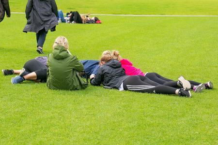 AMSTERDAM, NETHERLANDS - JUNE 25, 2017: Group of unknown young people are resting on a green grassy field near the Royal concert hall Concertgebouw in Museumplein district in Amsterdam.のeditorial素材