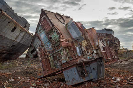 Huge rusty pieces of decommissioned marine ship that was cut and left on the shore.の写真素材