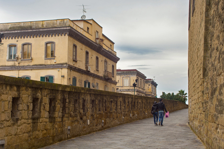 NAPLES, ITALY - OCTOBER 31, 2015: Unknown tourists walking near with the medieval castle Castel dell'Ovo. The castle is the oldest standing fortification in Naples.のeditorial素材