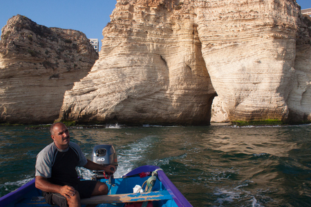 BEIRUT, LEBANON - AUGUST 14, 2014: Unknown man on a boat in the Mediterranean Sea near the famous Pigeon Rocks in Raouche District in Beirut.のeditorial素材