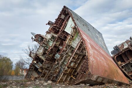 Huge rusty pieces of decommissioned marine ship that was cut and left on the shore.の写真素材