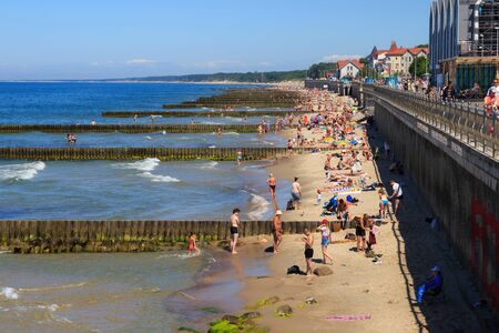 ZELENOGRADSK, KALININGRAD REGION, RUSSIA - JUNE 18, 2019: Unknown people resting on a sandy beach on the Baltic Sea coast in famous resort Zelenogradsk (formerly known as Cranz) at summer time.のeditorial素材