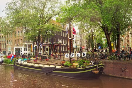 AMSTERDAM, NETHERLANDS - JUNE 25, 2017: Old buildings near the one of the water canals in the historical part of Amsterdam.のeditorial素材