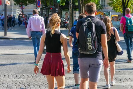 PARIS, FRANCE - JUNE 23, 2017: Unknown young people crossing a crosswalk in the center of Paris on the Avenue des Champs-Elysees.のeditorial素材
