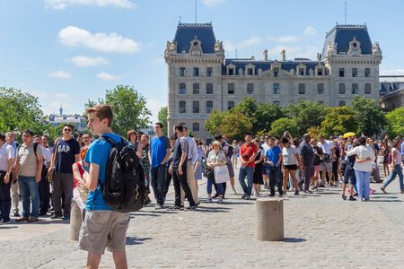 PARIS, FRANCE - JUNE 23, 2017: Queue to the Notre-Dame-de-Paris church on the place Jean Paul II (Parvis Notre-Dame). With the Prefecture of Police Headquarters on the background.のeditorial素材