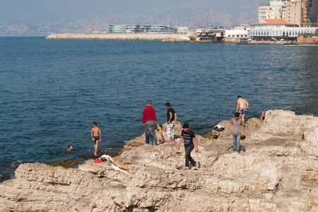 BEIRUT, LEBANON - AUGUST 14, 2014: Unknown people resting on the stones coast of the Mediterranean coast in the Raouche district in Beirut, Lebanon.のeditorial素材