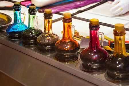 Multicolored glass flasks with various ingredients for the production of candy and other sweet food.の写真素材