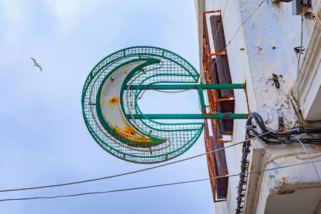 Green sign of the pharmacy in Tetouan (Northern Morocco) on the background of blue sky.の写真素材