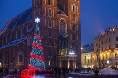 KRAKOW, POLAND - JANUARY 06, 2016: Beautiful night winter view of the Christmas tree near famous gothic St. Mary Basilica on the Main Market Square in historical center of Krakow.のeditorial素材