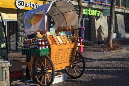 ZAKOPANE, POLAND - JANUARY 06, 2016: Selling of sheep cheese and high mountain honey in historical part of Zakopane in the Krupowki street in the sunny winter day.のeditorial素材