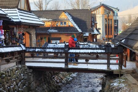 ZAKOPANE, POLAND - JANUARY 06, 2016: View of the old wooden bridge in the historical part of the Zakopane near Krupowki street in sunny winter day.のeditorial素材