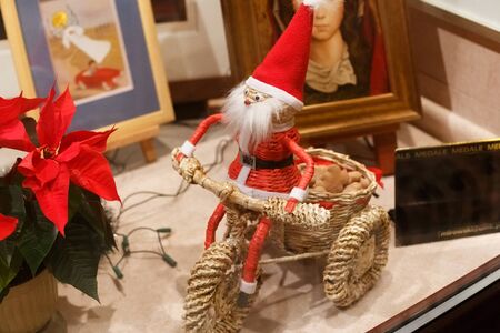 TORUN, POLAND - JANUARY 08, 2016: Little toy Santa Claus on a straw bike with a basket in a store window.のeditorial素材