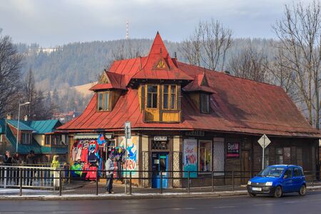 ZAKOPANE, POLAND - JANUARY 06, 2016: View of the old wooden building with rusty red metal roof in the historical part of the Zakopane on the Nowotarska street in sunny winter day.のeditorial素材