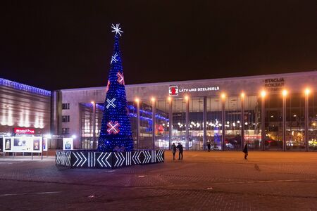 RIGA, LATVIA - JANUARY 14, 2018: Night winter view of the Christmas tree with national latvian ornaments near Central Railway Station of Riga.のeditorial素材