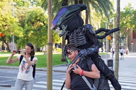 BARCELONA, SPAIN - MAY 16, 2017: Unknown actor in Alien costume is photographed with tourists in...