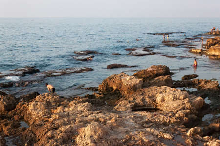 BEIRUT, LEBANON - AUGUST 14, 2014: Unknown people resting on the stones coast of the Mediterranean coast in the Raouche district in Beirut, Lebanon.のeditorial素材
