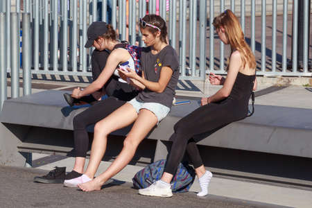 BARCELONA, SPAIN - MAY 16, 2017: Unknown young girls sitting on a bench in center of Barcelona in...